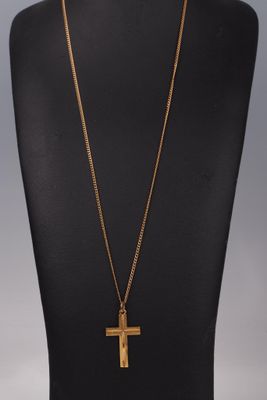un collier avec une croix en or sur un mannequin