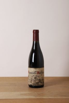 une bouteille de vin rouge posée sur une table en bois