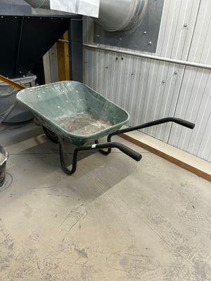 a wheelbarrow in the middle of a dirty room