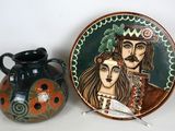 une assiette sur laquelle figurent un homme et une femme, à côté d'un vase
