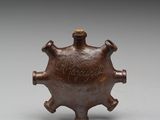 un vieux vase en bronze orné d'un motif décoratif sur le dessus