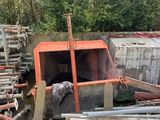 un tas de tuyaux métalliques à côté d'un tas de bois