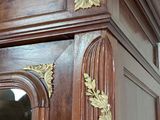 a large wooden cabinet with a mirror on top of it