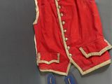 an image of a red vest and blue shoes on a gray surface