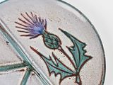 a glass plate with a thistle design on it
