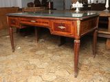 un bureau en bois avec un plateau en verre dans une pièce
