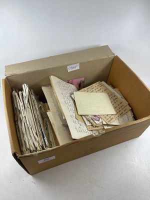 a box full of old letters and papers sitting on a table