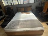 un lit sur lequel est posé un matelas, dans une chambre