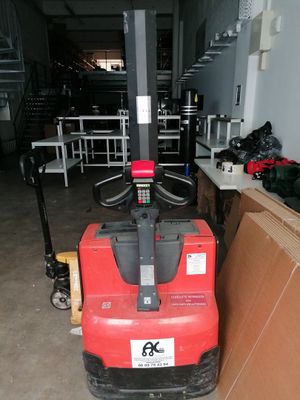 a red fork lift truck parked in a warehouse