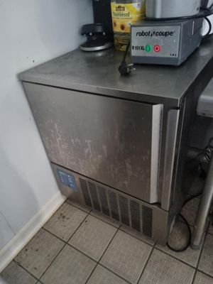 un petit réfrigérateur argenté posé dans un coin de la cuisine