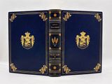 un vieux livre bleu aux bords dorés, orné d'un blason sur la couverture