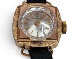 a close up of a watch on a white surface