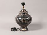 a black and gold vase sitting on a white surface