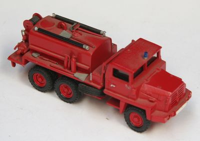 un petit camion rouge posé sur une surface blanche