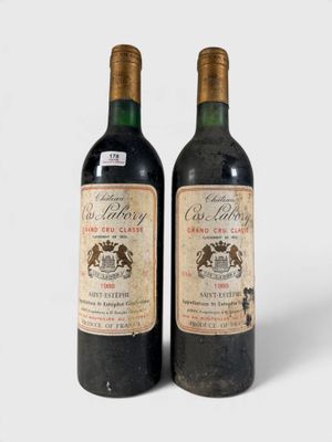 deux bouteilles de vin posées l'une à côté de l'autre sur une surface blanche