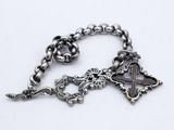 a close up of a silver bracelet with a cross on it