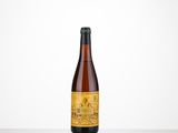 une bouteille de bière posée sur une table près d'un mur blanc