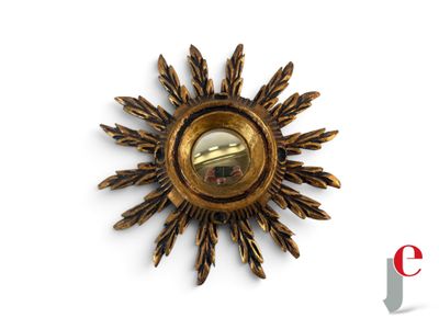 a gold sunburst with a mirror in the middle