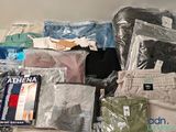 une pile de vêtements posée sur un lit