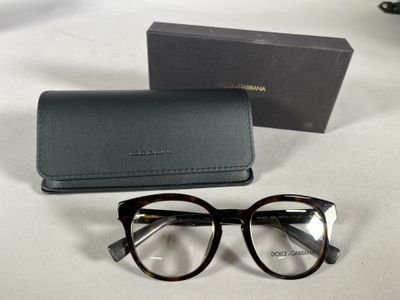 Des lunettes de soleil et un étui sont posés sur une table, à côté d'une paire de lunettes