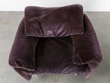 a purple chair that is sitting in the corner of a room