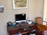a desk with a computer and a chair in a room