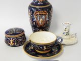 a blue and gold vase, a cup, saucer, and saucer