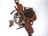 une selle de cheval avec une corde et un oiseau posé au sol