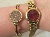 two wrist watches on a woman ' s arm