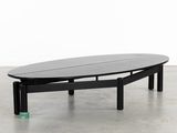 an oval coffee table with a black top and black legs