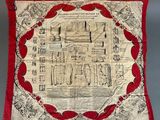 une couette rouge et blanche sur laquelle est représenté un bâtiment