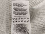 the back of a white sweater with a label on it