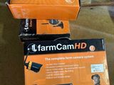 deux cartons contenant des caméras FarmCam HD posés par terre
