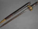 pair of two swords with a wooden handle on a gray surface