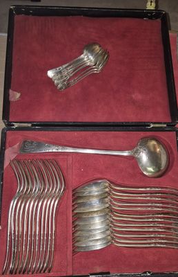 de nombreuses cuillères et fourchettes dans un coffret posé sur une table