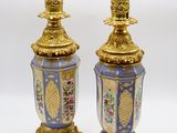 une paire de vases bleus et dorés ornés de fleurs sur fond blanc