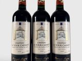 trois bouteilles de vin rouge posées l'une à côté de l'autre sur une surface blanche