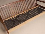 a wooden bench with a metal frame and a rattan seat