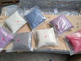 many bags of different colored pillows on a cardboard box