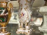 many vases that are on display in a glass case