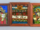 trois tableaux encadrés représentant Jésus et d'autres peintures religieuses accrochés au mur