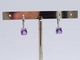 pair of amethorate and diamond earrings on a metal stand