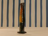 a vase that is sitting on a table in front of a striped wall