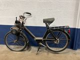a black bicycle parked against a white and blue wall