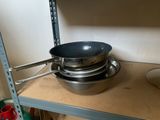 a stack of pots and pans on a shelf in a kitchen