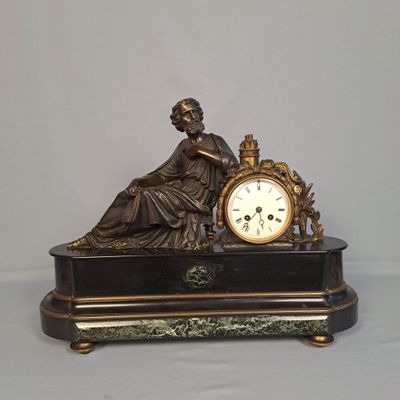 une statue de femme tenant une horloge sur une table