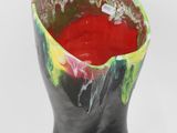 a black vase with a red substance inside of it