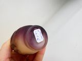 une personne tenant une bouteille sur laquelle est collé un autocollant