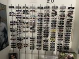 many different shades of sunglasses on display in a store
