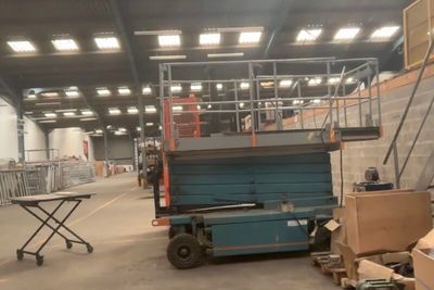 a man on a scissor in a large warehouse